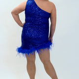 This is JK2401 in our collection Johnathan Kayne for Sydney's Closet. This plus size party dress comes in blue, red, black and white. This dress is one shoulder, all over sequins, an asymmetrical skirt, and has a feather hem.