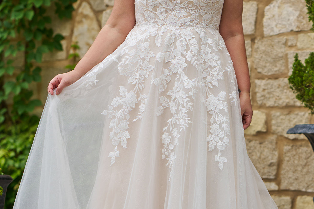 Michelle Bridal style MB2521 is available in ivory or ivory/champagne in plus sizes 14-40.  Square neckline, 1 inch illusion straps covered in leaf lace applqiues. A-line skirt with long train and optional bodice lining included.