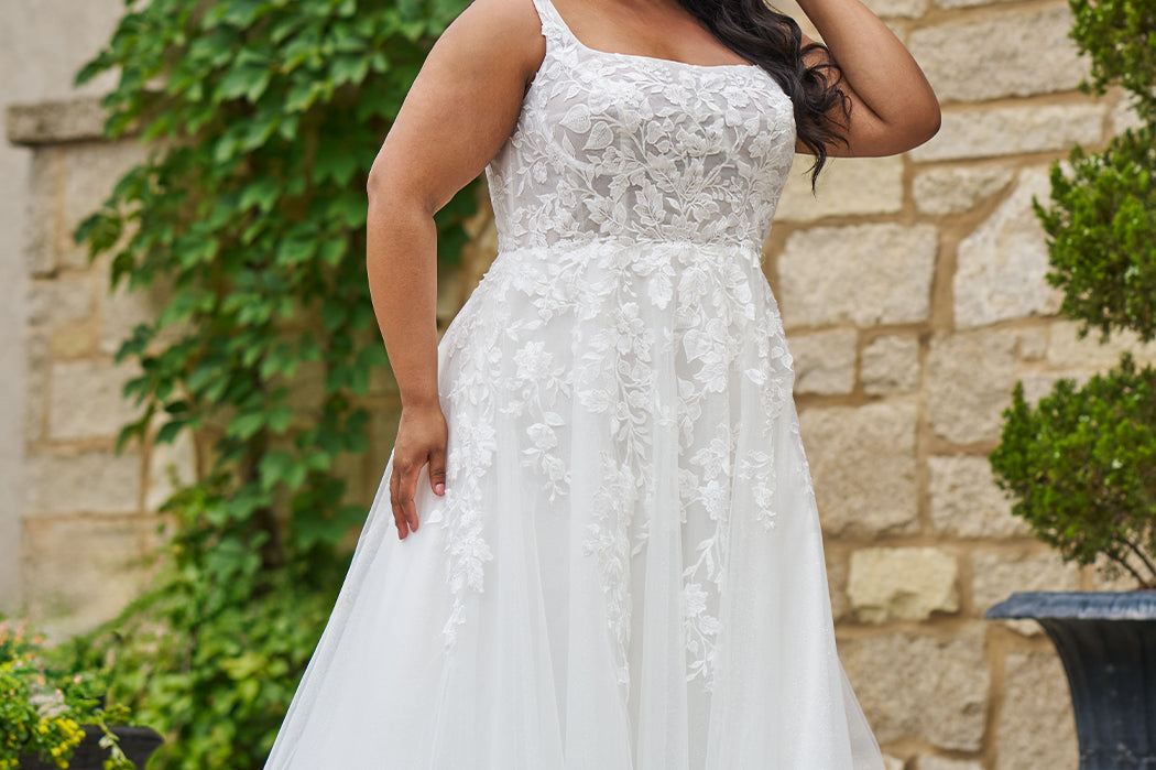 Michelle Bridal style MB2521 is available in ivory or ivory/champagne in plus sizes 14-40.  Square neckline, 1 inch illusion straps covered in leaf lace applqiues. A-line skirt with long train and optional bodice lining included.