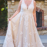 Plus size A-line oversized floral weding dress in ivory or champagne. Style MB2525 from Michelle Bridal by Sydney's Closet has illusions straps covered in appliques, natural waisltine, long flowy A-line skirt and long train with covered buttons.