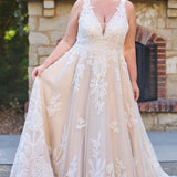 Plus size A-line oversized floral weding dress in ivory or champagne. Style MB2525 from Michelle Bridal by Sydney's Closet has illusions straps covered in appliques, natural waisltine, long flowy A-line skirt and long train with covered buttons.