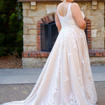 Plus size A-line oversized floral weding dress in ivory or champagne. Style MB2525 from Michelle Bridal by Sydney's Closet has illusions straps covered in appliques, natural waisltine, long flowy A-line skirt and long train with covered buttons.