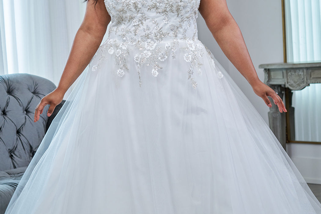 Sydney's Closet plus size wedding dress with lace up back and modesty panel.  V-neckline embelished with 3D floral appliques and silver stones.  Full A-line skirt and long train. Style SC5345