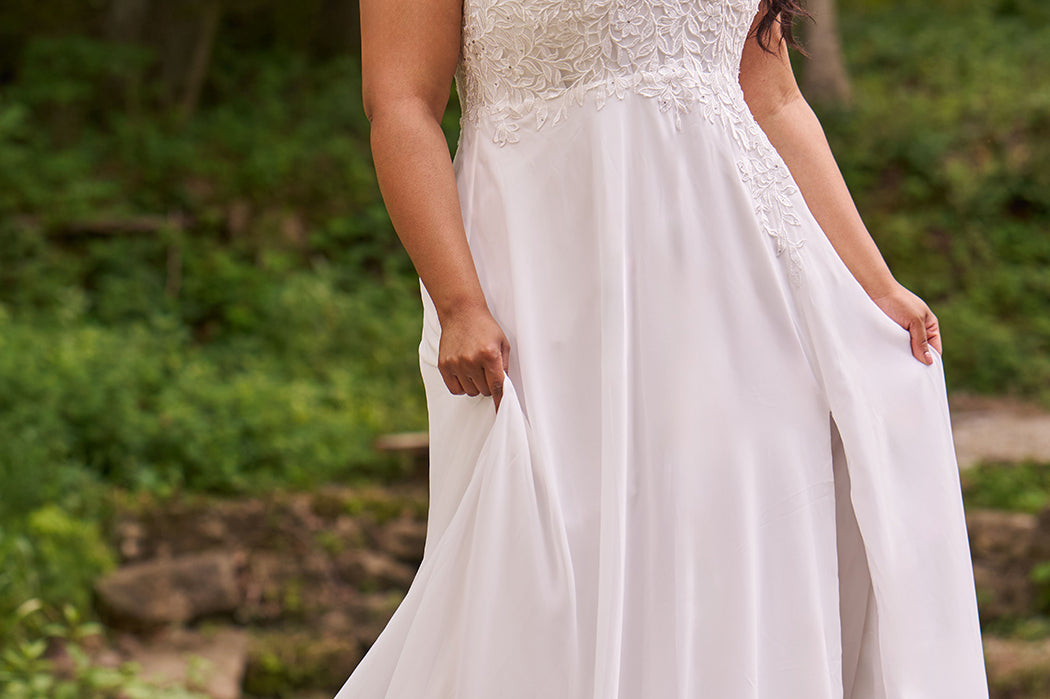 Sydney's Closet plus size wedding dress with sweetheart neckline,spaghetti straps and flowing chiffon skirt with slit. Lace covered bodice comes unlined with optional lining included. Style SC5348 is avialable in ivory