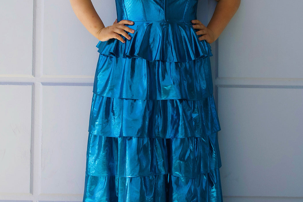 SC7405 by Sydney's Closet. Plus size strapless sweetheart metallic knit gown with exposed boning on bodice.  Tiered A-line skirt slit. Available in magenta pink, copper gold/brown and turq blue green.