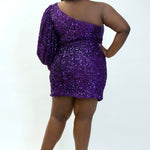This is SC8133 in our Sydney's Closet Homecoming collection. This plus size party dress comes in black, blue, purple, and red! This dress has a one shoulder long sleeve pouf sleeve, a cutout bodice, and a natural waistline. This fitted all over sequin dress has the spotlight as the most perfect dress for this homecoming season!