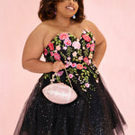 SC8137 Front view. Black sparkle tulle short a-line party dress with pink floral embroidered roses. Strapless sweetheart neckline, long invisible center back zipper.  Available only in black floral. Curvy sizes 10-32. Model in picture is 5 foot 9 inches and a size 16.