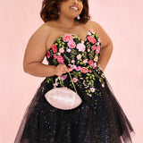 SC8137 Front view. Black sparkle tulle short a-line party dress with pink floral embroidered roses. Strapless sweetheart neckline, long invisible center back zipper.  Available only in black floral. Curvy sizes 10-32. Model in picture is 5 foot 9 inches and a size 16.