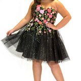 SC8137 Front view. Black sparkle tulle short a-line party dress with pink floral embroidered roses. Strapless sweetheart neckline, long invisible center back zipper.  Available only in black floral. Curvy sizes 10-32. Model in picture is 5 foot 9 inches and a size 16.