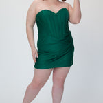 Short fitted green party dress SC8143 by Sydney's Closet. Front view.  Strapless, exposed boning basque waist and ruched fitted skirt in shimmer stretch knit. Availability in black, purple, red, ivory, green and royal. Model in picture is 5'9.