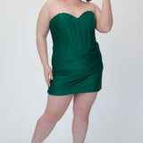 Short fitted green party dress SC8143 by Sydney's Closet. Front view.  Strapless, exposed boning basque waist and ruched fitted skirt in shimmer stretch knit. Availability in black, purple, red, ivory, green and royal. Model in picture is 5'9.