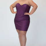 Short fitted purple party dress SC8143 by Sydney's Closet. Front view.  Strapless, exposed boning basque waist and ruched fitted skirt in shimmer stretch knit. Long invisible center back zipper. Availability in black, purple, red, ivory, green and royal. Model in picture is 5'9.