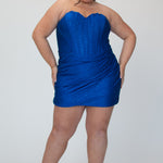 Short fitted royal blue party dress SC8143 by Sydney's Closet. Front view.  Strapless, exposed boning basque waist and ruched fitted skirt in shimmer stretch knit. Long invisible center back zipper. Availability in black, purple, red, ivory, green and royal. Model in picture is 5'9.