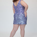Short fitted lilac purple party dress SC8145 by Sydney's Closet. Back view.  Fully sequined short gown, with 3D floral embellishments on bodice. Thick bra-friendly straps, deep v-neckline. Long invisible center back zipper. Availability in lilac purple, onyx black and ruby red . Model in picture is 5'9.