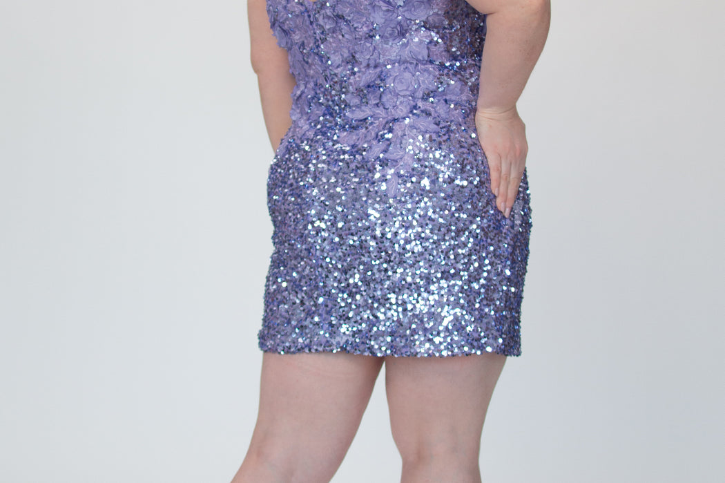 Short fitted lilac purple party dress SC8145 by Sydney's Closet. Back view.  Fully sequined short gown, with 3D floral embellishments on bodice. Thick bra-friendly straps, deep v-neckline. Long invisible center back zipper. Availability in lilac purple, onyx black and ruby red . Model in picture is 5'9.