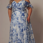 Plus size picnic dress in blue and white floral chiffon print. Criss-cross pleated bodice with spaghetti straps and drape sleeve. A-line skirt and center back zipper. Style SC7421 by Sydney's Closet.