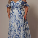 Plus size picnic dress in blue and white floral chiffon print. Criss-cross pleated bodice with spaghetti straps and drape sleeve. A-line skirt and center back zipper. Style SC7421 by Sydney's Closet.