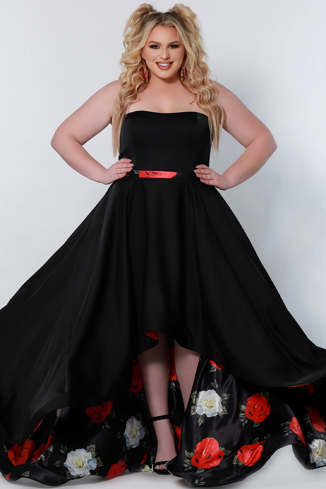 CE2203 Celebrations by Sydney's Closet strapless aline silhouette with semi sweetheart neckline and optional straps dress features a high low skirt with rose floral design underneath a 1 inch floral satin belt and a sweep train zipper back closure available in black/floral