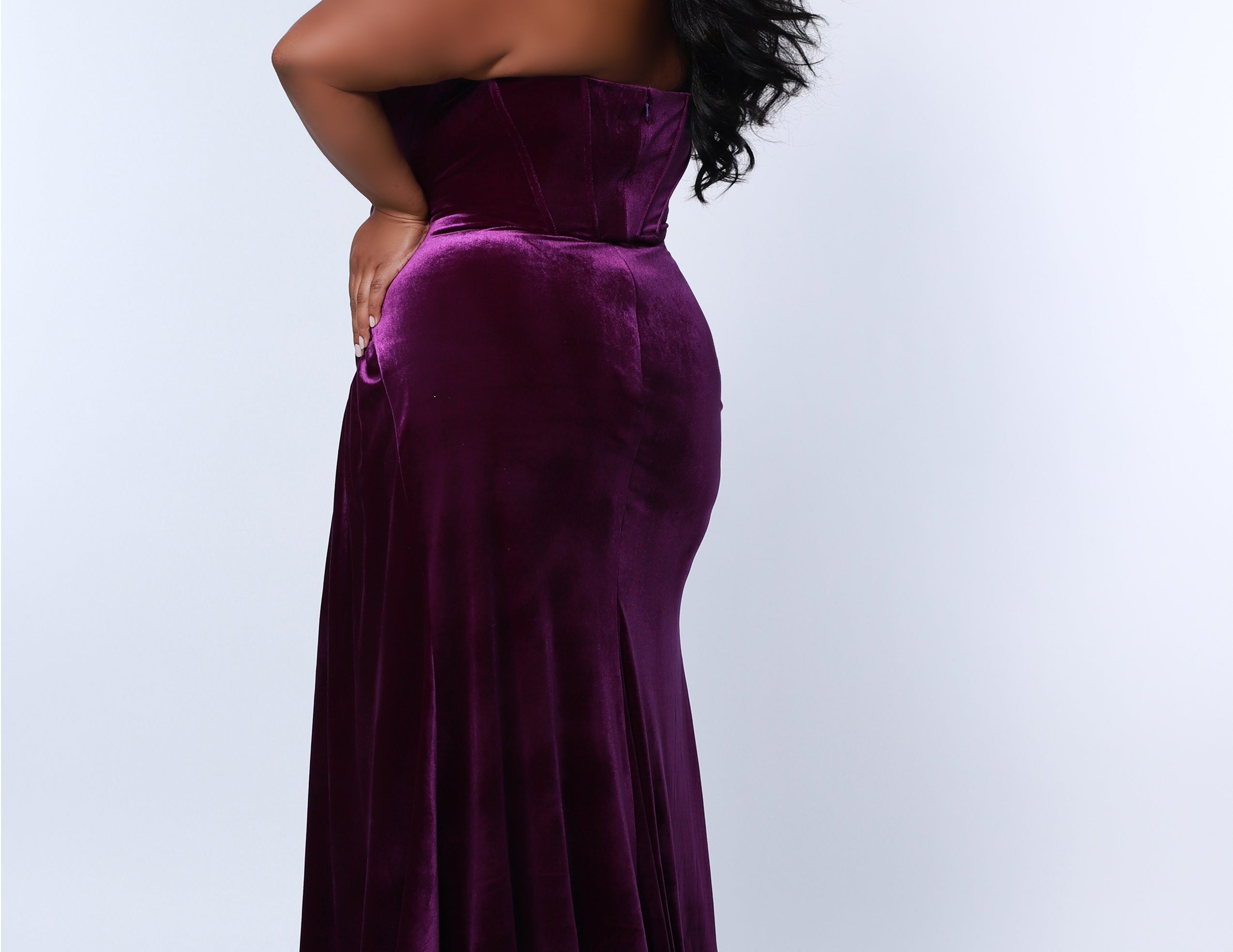 Sydney’s Closet SC7342 Deep purple. Slim/Fitted silhouette, strapless with optional spaghetti straps. Modified Basque waist, exposed corset boning on bodice and a ruched waist. Stretch velvet, with high slit and sweep train.