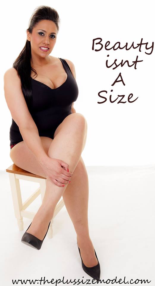 Plus Size model Sharon D from the UK wearing a black body suit, heels and sitting on a chair. Text says "Beauty isn't a size"