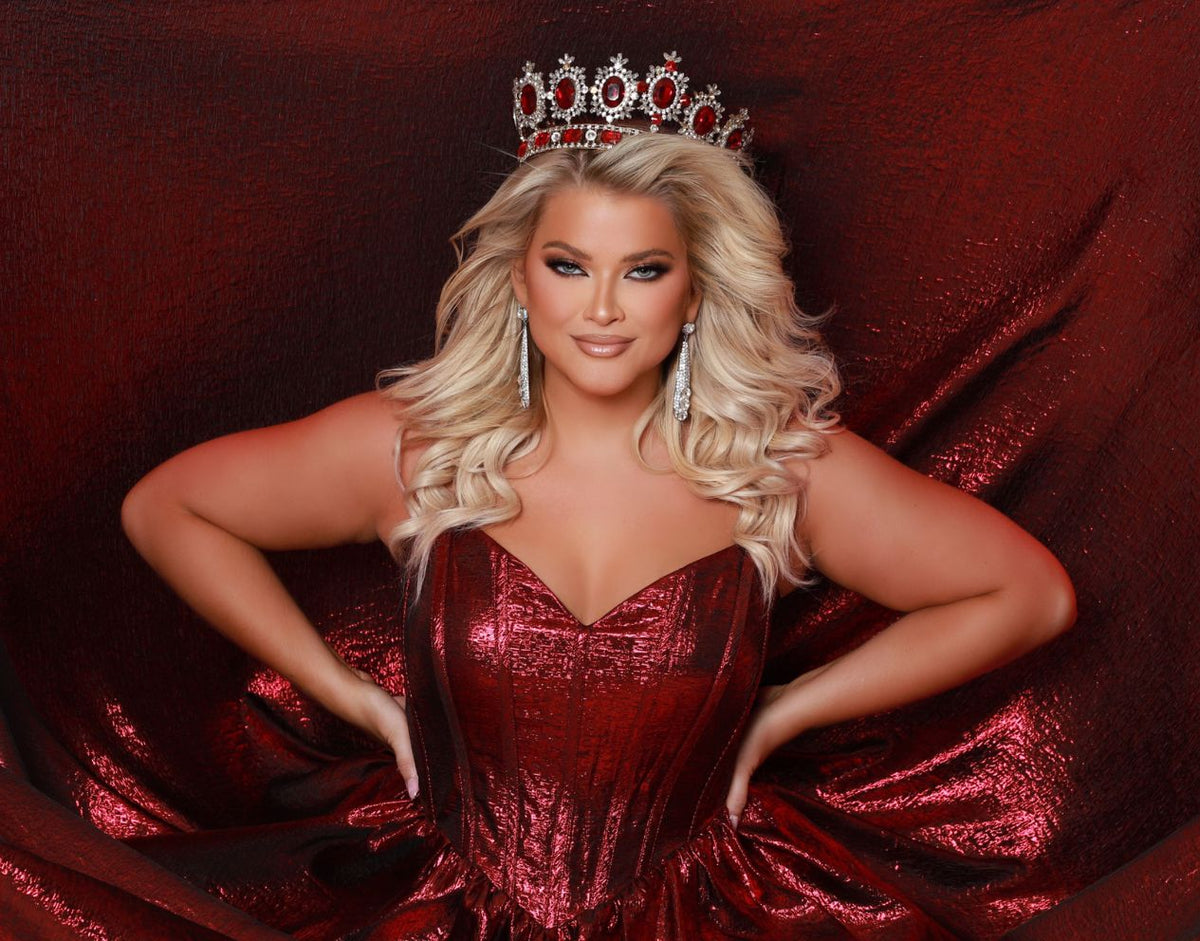 Woman in a red dress and tiara against a red background