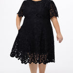 Plus size little black dress made of Guipure lace. Cap sleeves, scoop neckline and center back zipper. CE2601 available in sizes 14-24 in black. Celebrations by Sydney's Closet.