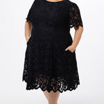 Plus size little black dress made of Guipure lace. Cap sleeves, scoop neckline and center back zipper. CE2601 available in sizes 14-24 in black. Celebrations by Sydney's Closet.