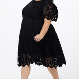 Plus size little black dress made of Guipure lace. Cap sleeves, scoop neckline and center back zipper. CE2601 available in sizes 14-24 in black. Celebrations by Sydney's Closet.