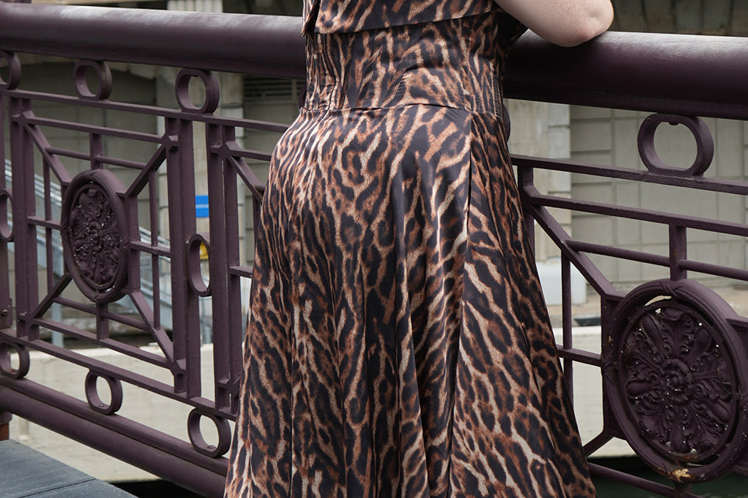 Plus size Tee length animal print dress.  fold over cuff detail, exposed corset boning, natural waistline, and A-line skirt with pockets and center back zipper. CE2603 available in sizes 14-24 in animal print. Celebrations by Sydney's Closet.