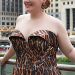 Plus size Tee length animal print dress.  fold over cuff detail, exposed corset boning, natural waistline, and A-line skirt with pockets and center back zipper. CE2603 available in sizes 14-24 in animal print. Celebrations by Sydney's Closet. 