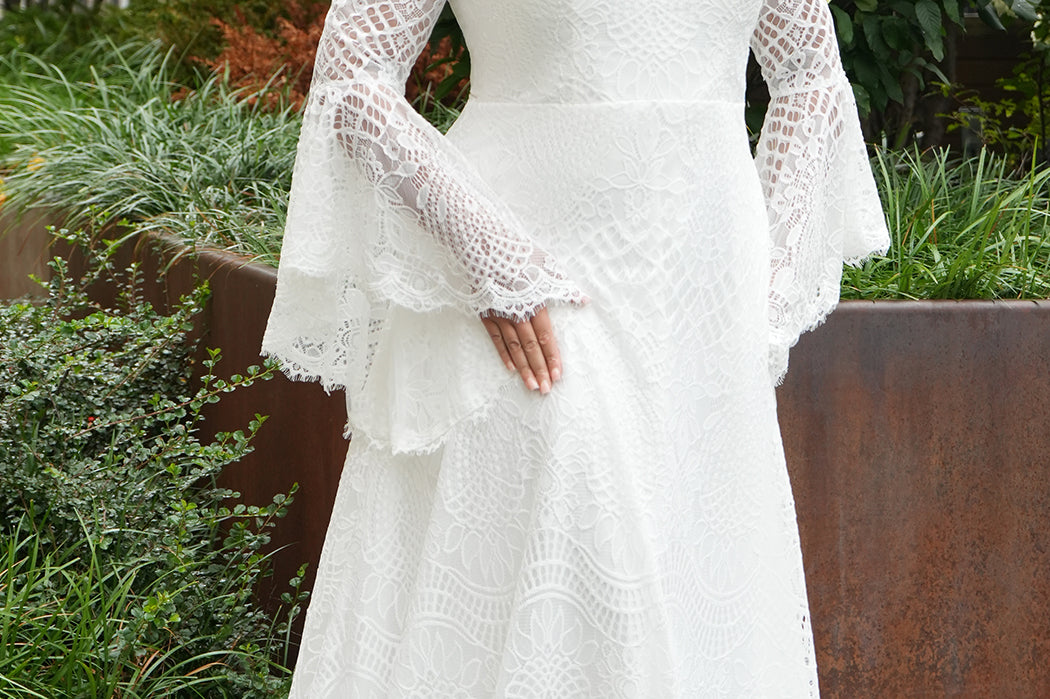 Boho crochet lace plus size wedding dress with V-neckline, illusion lace straps, illusion long flowy bell sleeves, natural wiasltine and slim A-line skirt finished with scalloped eyelash hem.  Available in ivory. Celebrations by Sydney's Closet style CE2604
