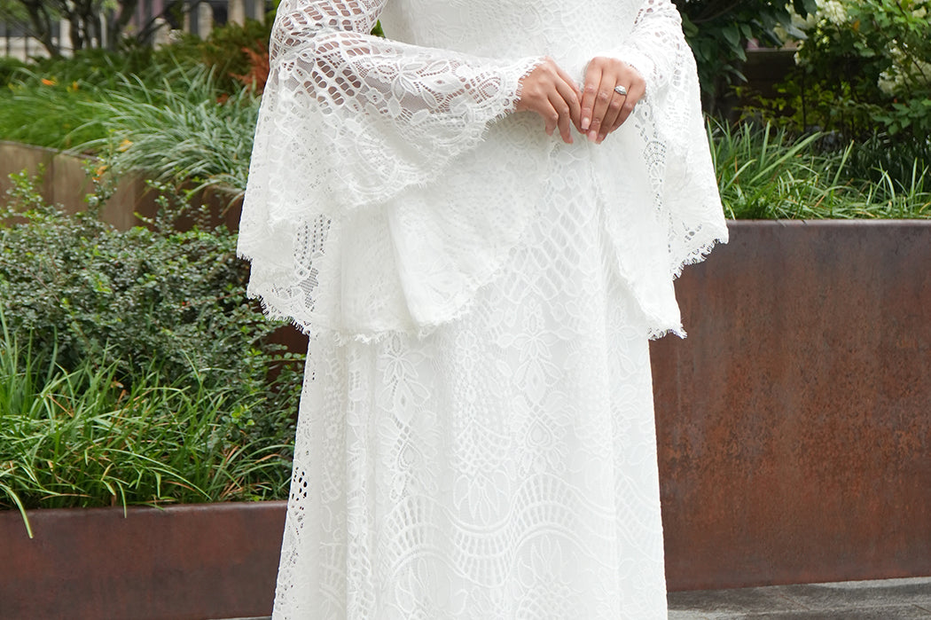 Boho crochet lace plus size wedding dress with V-neckline, illusion lace straps, illusion long flowy bell sleeves, natural wiasltine and slim A-line skirt finished with scalloped eyelash hem.  Available in ivory. Celebrations by Sydney's Closet style CE2604
