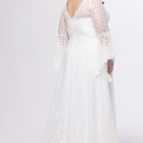 Boho crochet lace plus size wedding dress with V-neckline, illusion lace straps, illusion long flowy bell sleeves, natural wiasltine and slim A-line skirt finished with scalloped eyelash hem.  Available in ivory. Celebrations by Sydney's Closet style CE2604
