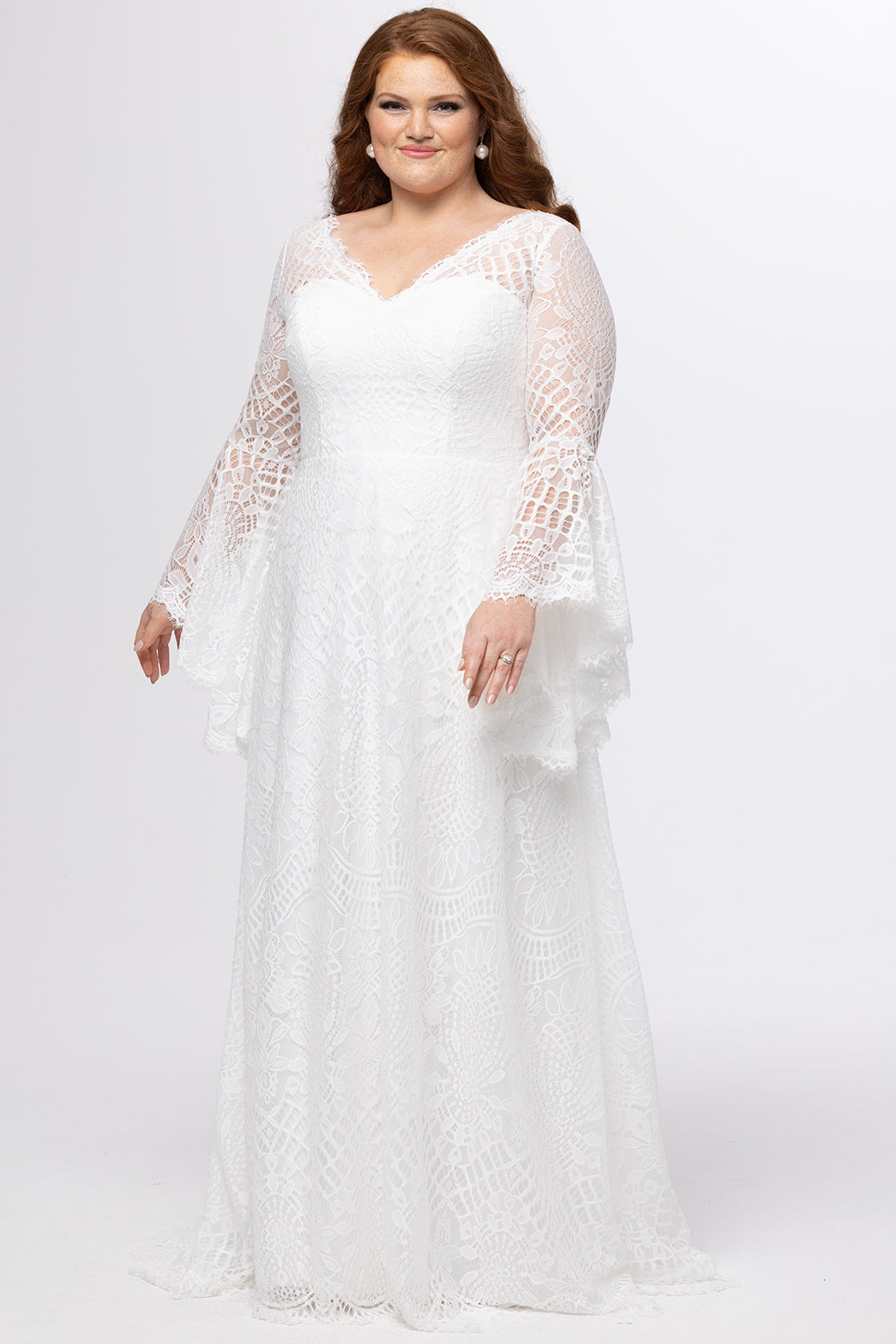 Boho crochet lace plus size wedding dress with V-neckline, illusion lace straps, illusion long flowy bell sleeves, natural wiasltine and slim A-line skirt finished with scalloped eyelash hem.  Available in ivory. Celebrations by Sydney's Closet style CE2604