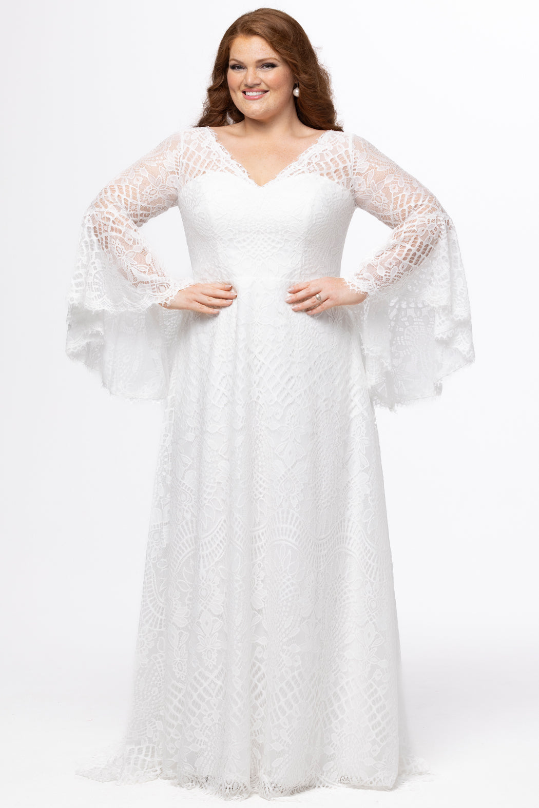 Boho crochet lace plus size wedding dress with V-neckline, illusion lace straps, illusion long flowy bell sleeves, natural wiasltine and slim A-line skirt finished with scalloped eyelash hem.  Available in ivory. Celebrations by Sydney's Closet style CE2604