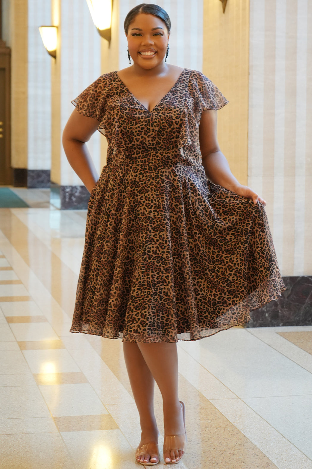 Celebrations by Sydney's Closet style CE2605 in animal print. 

Knee length plus size animal print dress.  V-neck, short flutter sleeves, natural waistline, pockets and ruffles on bodice princess seams. Made from printed chiffon and light satin lining. Center back zipper. 