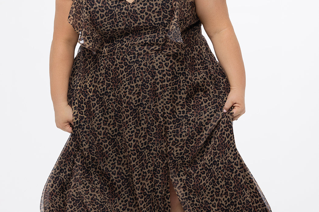 Plus size A-line floor length animal print gown. Flutter cap sleeves, ruffle starting at highpoint of shoulder down to natural waistline. Left leg slit and center back zipper.  CE2606 available in sizes 14-32 in animal print. Celebrations by Sydney's Closet.