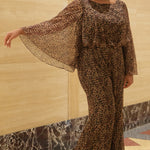 Plus size one-piece animal print jumpsuit. Long flowy chiffon sleeves and blouson bodice, elastic waist, and wide-leg pants. Center back zipper and scoop neckline. CE2607 available in sizes 14-28 in animal print. Celebration's by Sydney's Closet. 