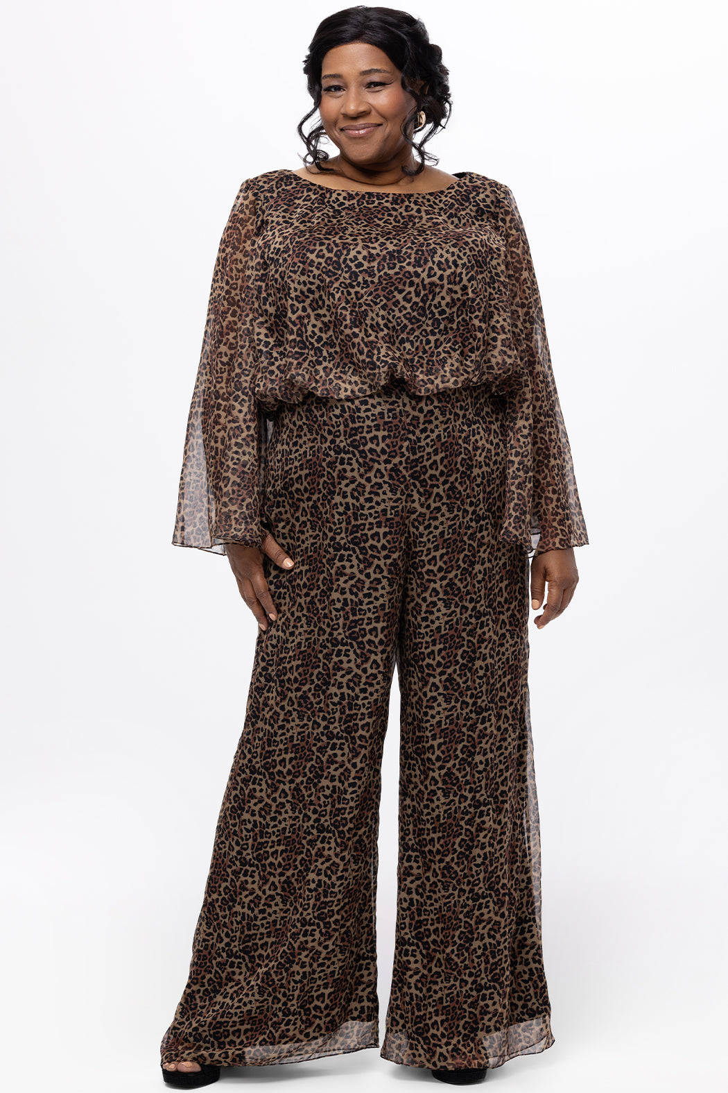 Plus size one-piece animal print jumpsuit. Long flowy chiffon sleeves and blouson bodice, elastic waist, and wide-leg pants. Center back zipper and scoop neckline. CE2607 available in sizes 14-28 in animal print. Celebration's by Sydney's Closet. 