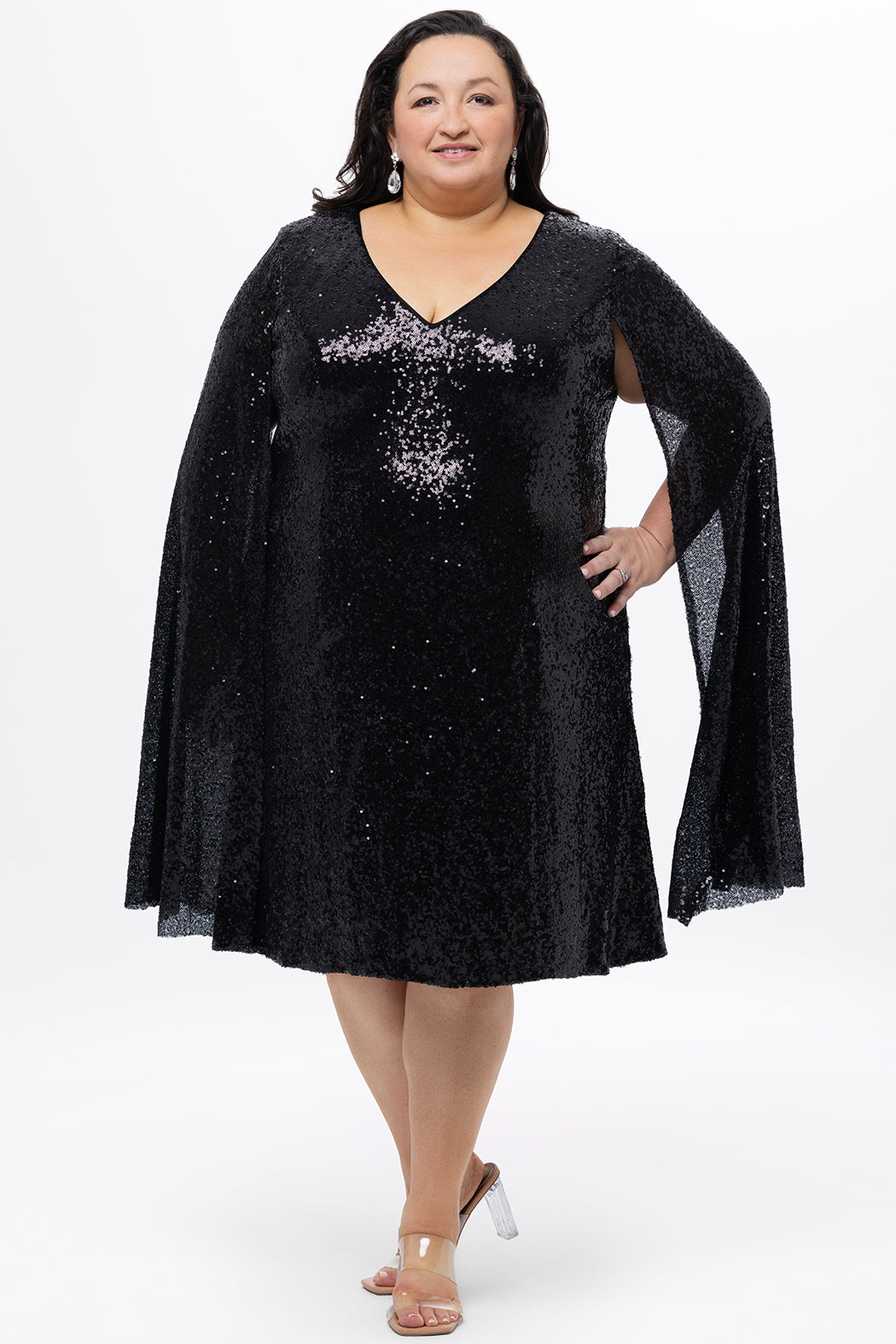 Sydney's Closet CE2609 in black.

Plus size sequin black short party dress. V-neckline, bra-friendly straps with attached cape sleeve detail, princess silhouette, slim A-line skirt. at knee-length.