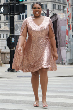 Sydney's Closet CE2609 in rose gold.

Plus size sequin rose gold metallic short party dress. V-neckline, bra-friendly straps with attached cape sleeve detail, princess silhouette, slim A-line skirt. at knee-length.