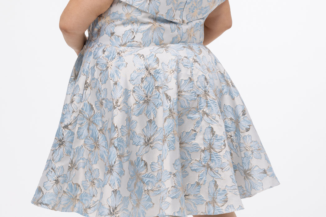 Celebrations by Sydney's Closet CE2610 in Light Blue Floral. 

Plus size knee-length party dress in metallic light blue floral brocde print. Off-the-shoulder neckline, natural waistline and A-line skirt with pockets. 
