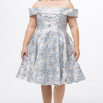 Celebrations by Sydney's Closet CE2610 in Light Blue Floral. 

Plus size knee-length party dress in metallic light blue floral brocde print. Off-the-shoulder neckline, natural waistline and A-line skirt with pockets. 