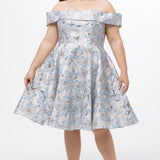 Celebrations by Sydney's Closet CE2610 in Light Blue Floral. 

Plus size knee-length party dress in metallic light blue floral brocde print. Off-the-shoulder neckline, natural waistline and A-line skirt with pockets. 