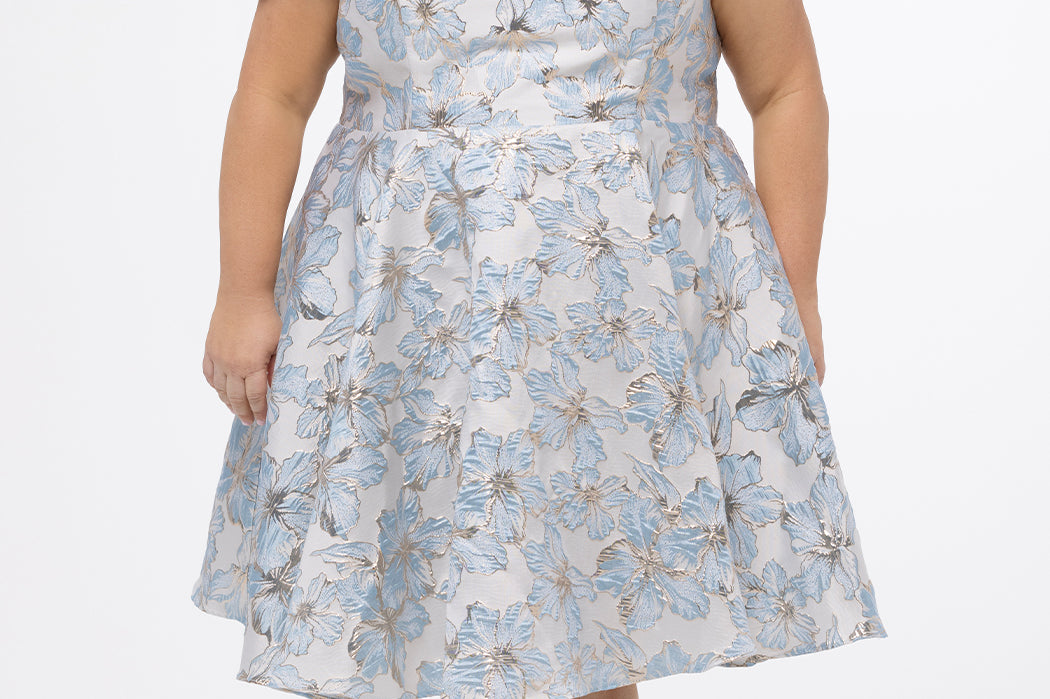 Celebrations by Sydney's Closet CE2610 in Light Blue Floral. 

Plus size knee-length party dress in metallic light blue floral brocde print. Off-the-shoulder neckline, natural waistline and A-line skirt with pockets. 