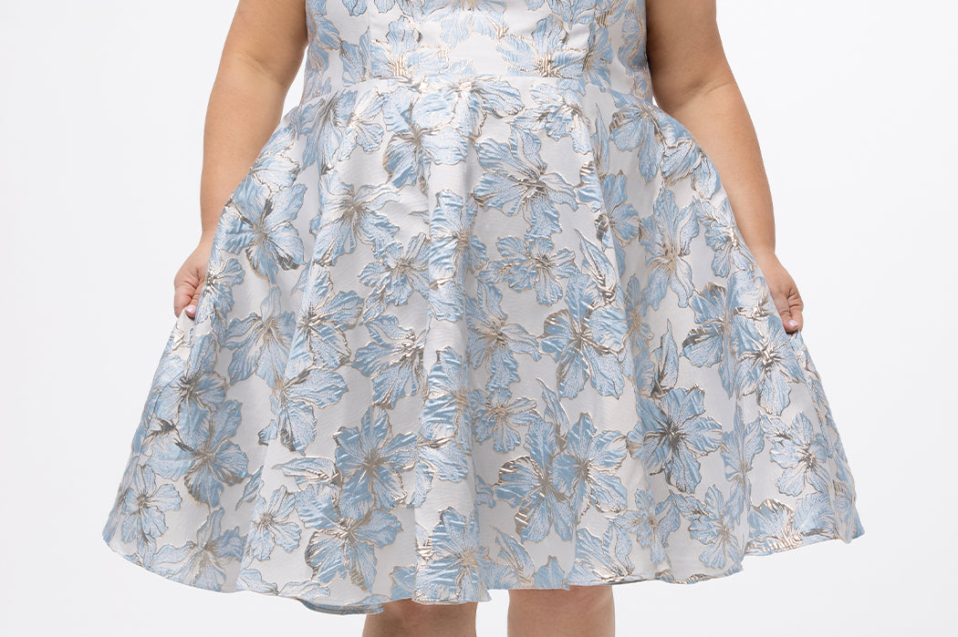 Celebrations by Sydney's Closet CE2610 in Light Blue Floral. 

Plus size knee-length party dress in metallic light blue floral brocde print. Off-the-shoulder neckline, natural waistline and A-line skirt with pockets. 