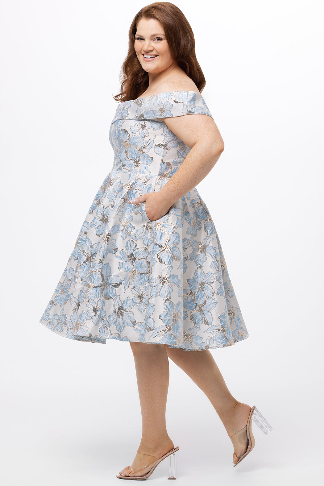 Celebrations by Sydney's Closet CE2610 in Light Blue Floral. 

Plus size knee-length party dress in metallic light blue floral brocde print. Off-the-shoulder neckline, natural waistline and A-line skirt with pockets. 