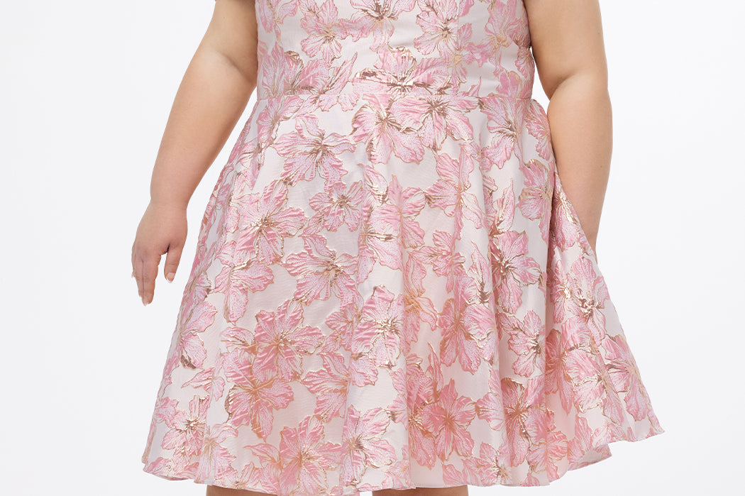 Celebrations by Sydney's Closet CE2610 in Light Pink Floral. 

Plus size knee-length party dress in metallic light pink floral brocde print. Off-the-shoulder neckline, natural waistline and A-line skirt with pockets. 