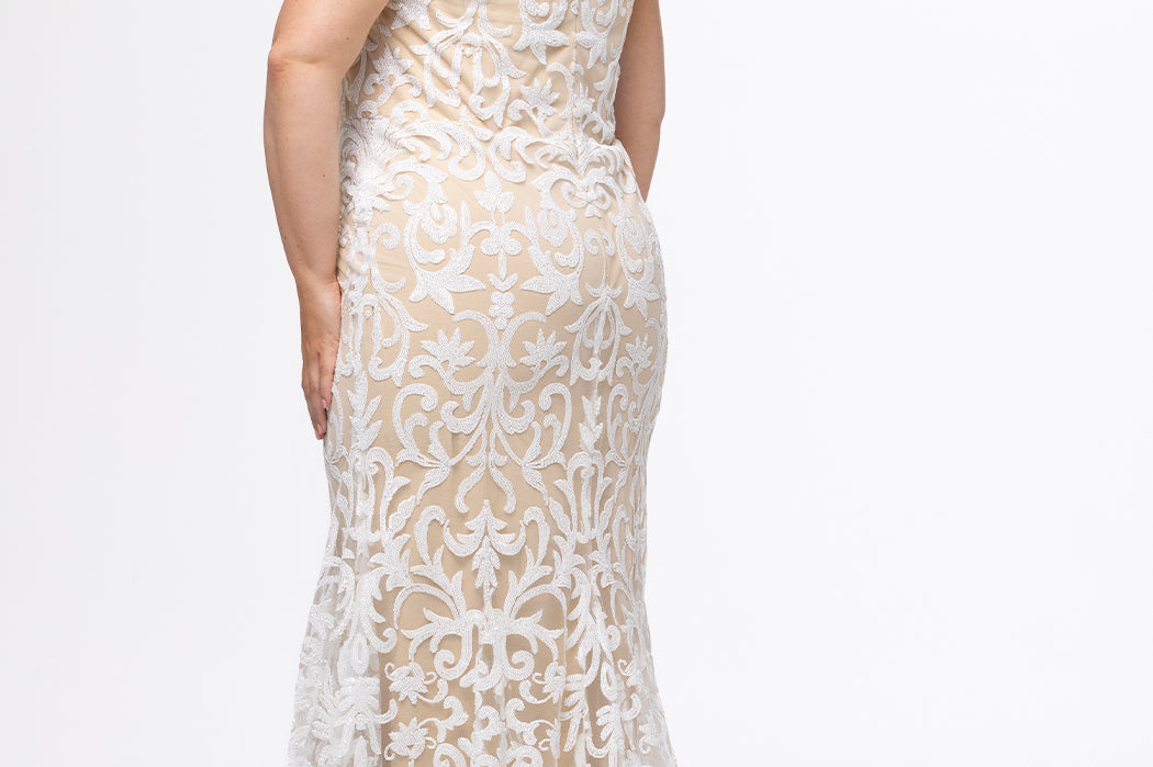 Plus-size woman wearing an off-the-shoulder nude and ivory sequin embroidered formal gown with sweetheart neckline, off-the-shoulder straps and fitted silhouette. CE2611 available from Sydney's Closet