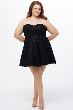 Celebrations by Sydney's Closet Style CE2612 in black. 

Plus size strapless black short mini party dress with sweetheart neckline, exposed corset boning on bustier bodice and mini skirt in all over stretch lace. 